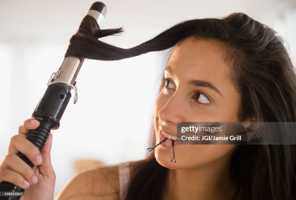 Hispanic teenager curing her hair