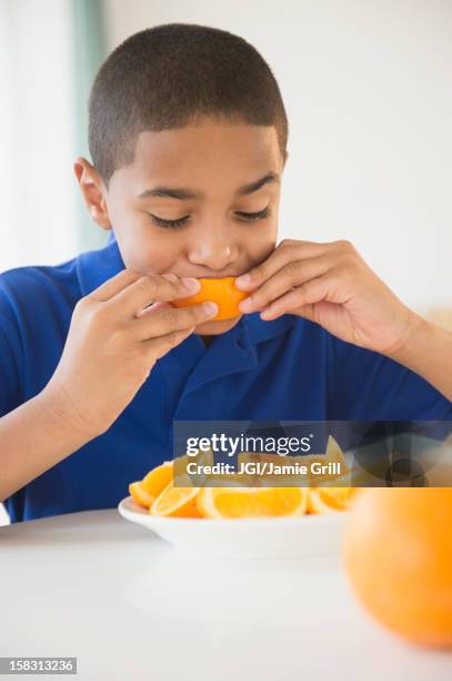hispanic boy eating orange sections - orange new jersey stock pictures, royalty-free photos & images