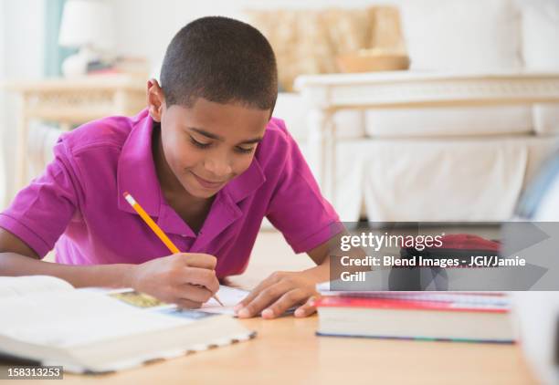 hispanic boy doing homework - 13 pencils stock-fotos und bilder