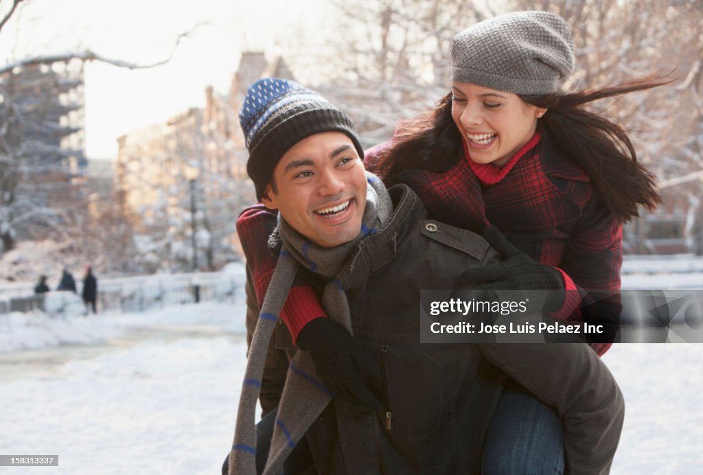Mixed race man carrying girlfriend on back
