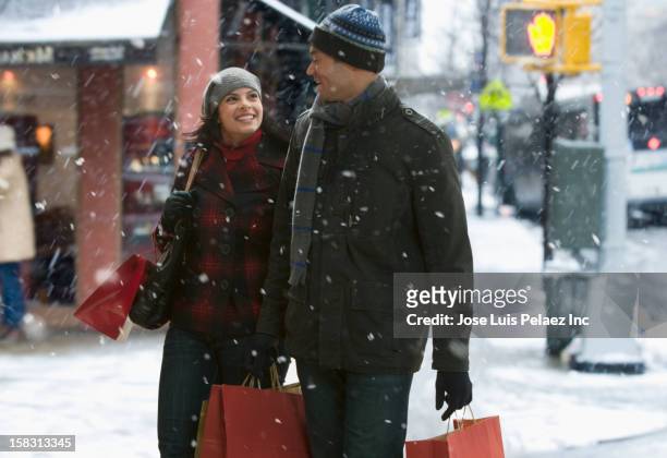 couple shopping together in the snow - christmas new york stock-fotos und bilder