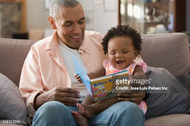 black father reading book to daughter - black baby 個照片及圖片檔