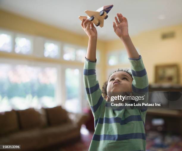 black boy playing with wooden airplane - child arms raised stock pictures, royalty-free photos & images