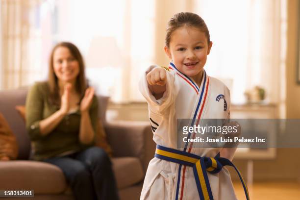 caucasian mother watching daughter practicing karate - karate girl stock pictures, royalty-free photos & images