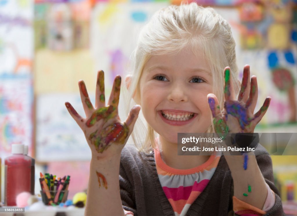 Caucasian girl with paint on hands