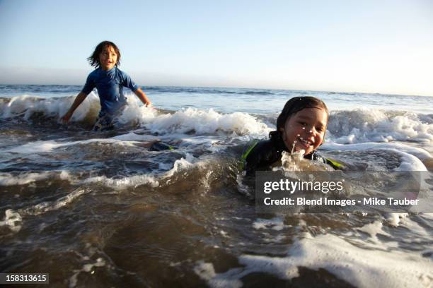 Mixed race boys swimming in ocean