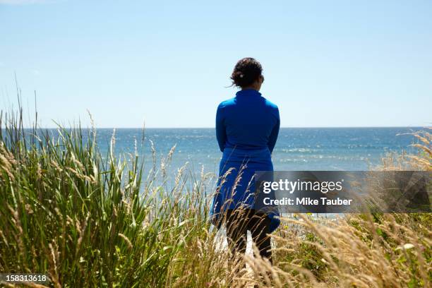 mixed race woman looking at ocean - black hair back stock pictures, royalty-free photos & images