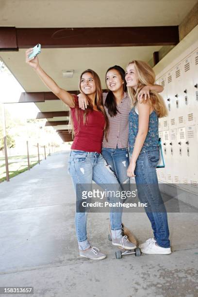 school friends taking self-portrait with cell phone - 3 teenagers mobile outdoors stock-fotos und bilder