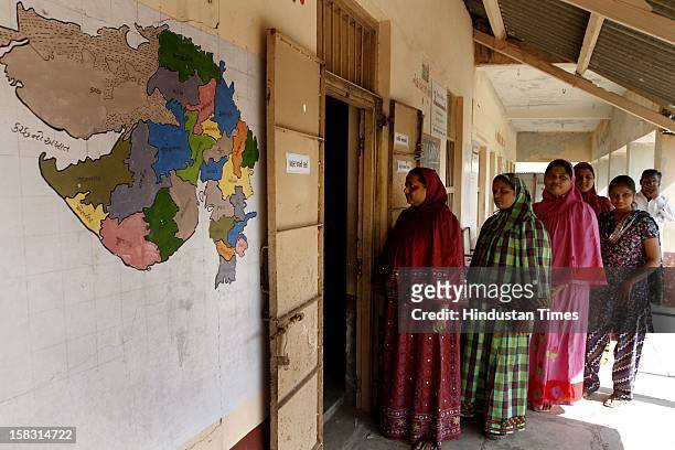 Voters standing in queue for casting their vote during the first phase polling of Gujarat assembly election at Viramgam on December 13, 2012 in...