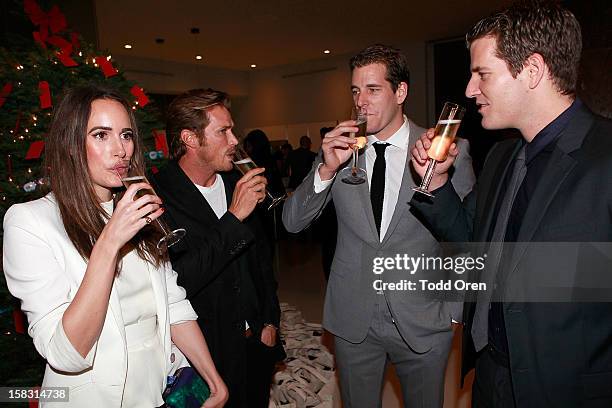 Host Louise Roe, Actor Jason Lewis, Cameron Winklevoss and Tyler Winklevoss toast at the Hukkster Holiday Party Hosted by Louise Roe and Founders...