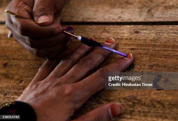 An Indian woman has her finger inked after casting her vote in the first phase polling of Gujarat assembly elections on December 13, 2012 in Surat,...