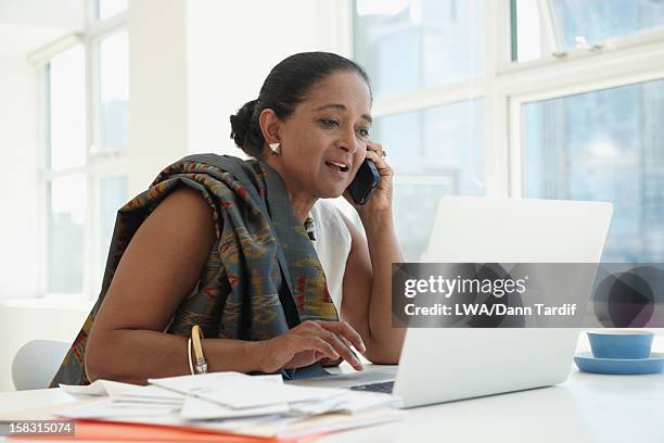 indian businesswoman using cell phone at desk - hair bun scarf woman stock pictures, royalty-free photos & images