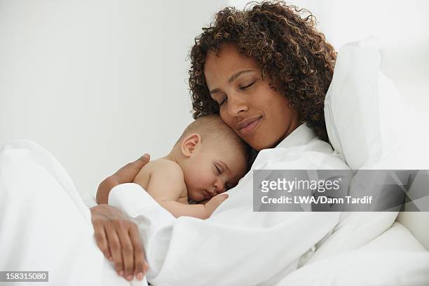 black mother laying in bed with baby - black baby 個照片及圖片檔