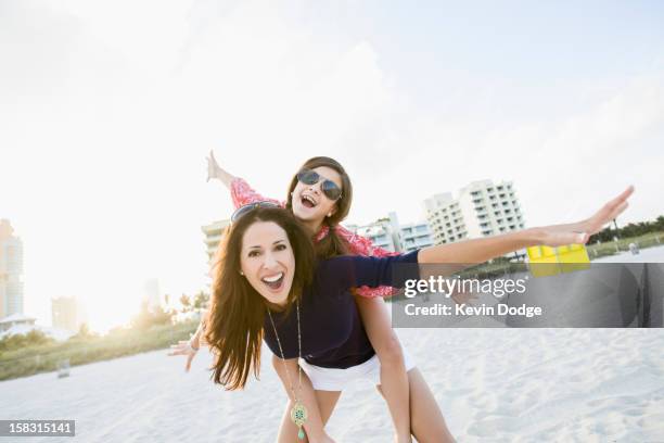 hispanic mother and daughter playing on beach - miami beach imagens e fotografias de stock