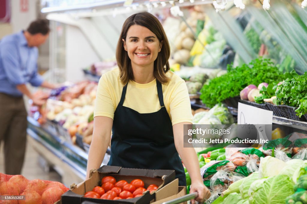 Caucasian worker in produce section of grocery store