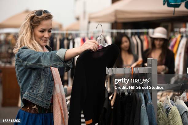 caucasian woman shopping at flea market - rommelmarkt stockfoto's en -beelden