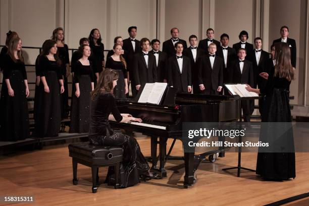 pianist and choir performing on stage - koor stockfoto's en -beelden