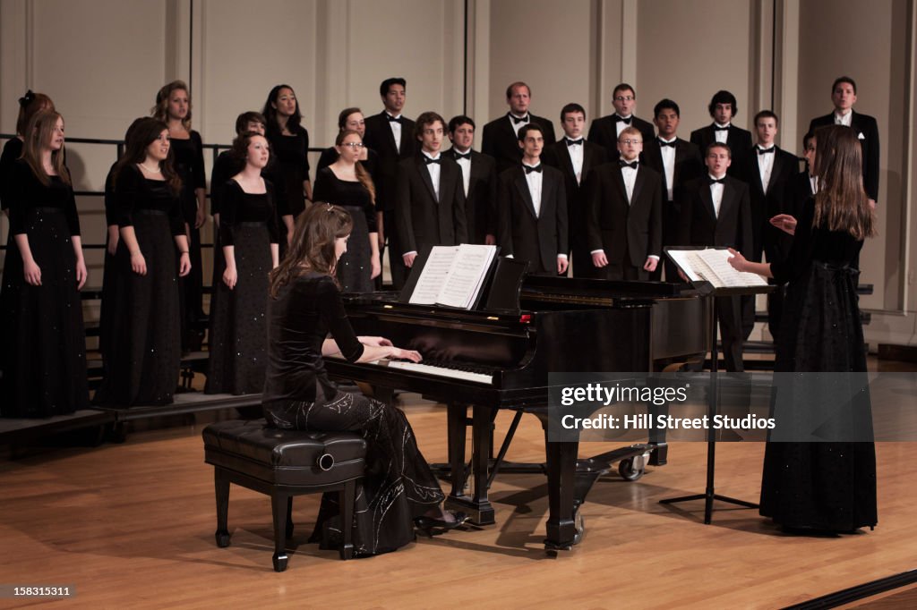 Pianist and choir performing on stage