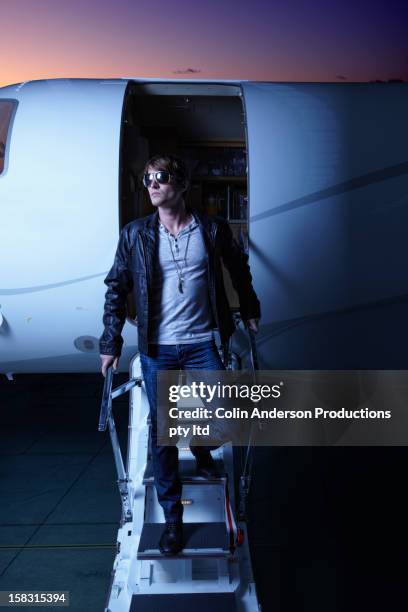 caucasian man walking down steps of private jet - fabolous musician stock pictures, royalty-free photos & images