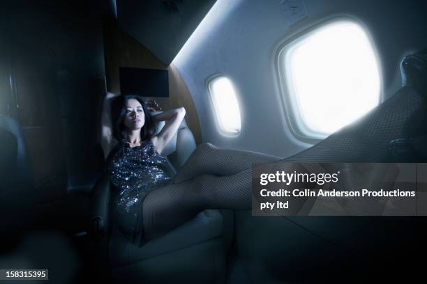 young woman flying on private jet - passenger muzikant stockfoto's en -beelden
