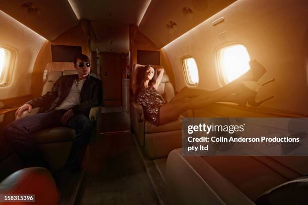 young couple flying on private jet - passenger muzikant stockfoto's en -beelden