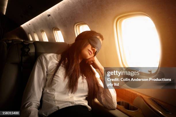 pacific islander businesswoman sleeping on private jet - eye mask foto e immagini stock