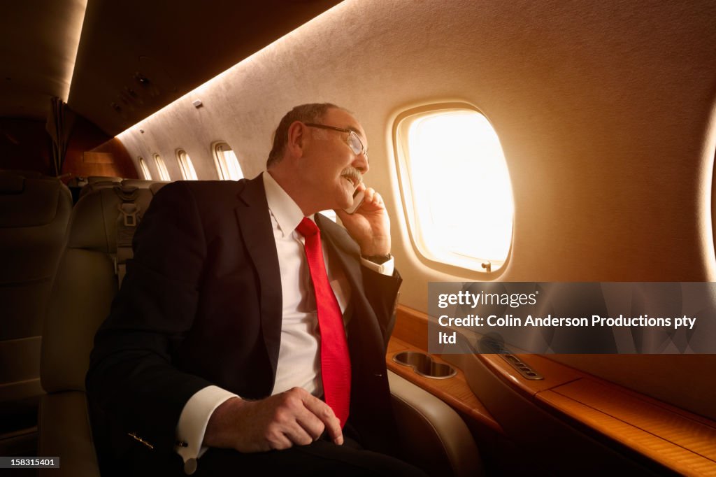 Caucasian businessman flying on private jet