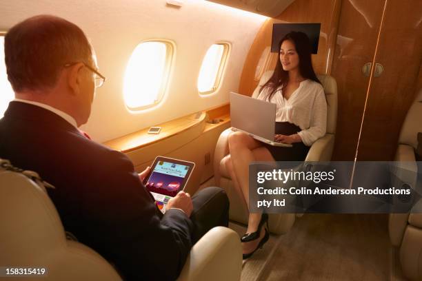 business people flying on private jet - rico e anderson fotografías e imágenes de stock