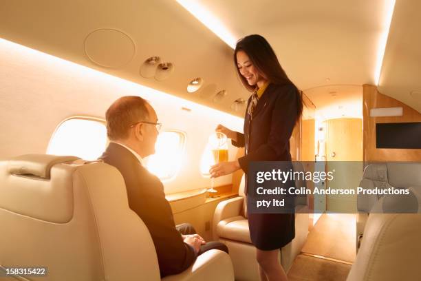 stewardess serving passenger on private jet - private aeroplane stock-fotos und bilder