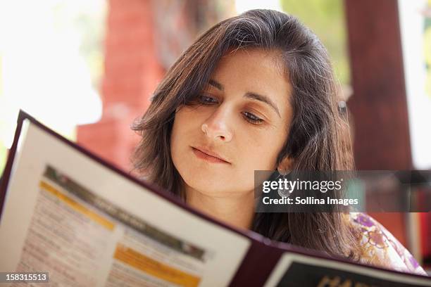 hispanic woman looking at restaurant menu - ordering food stock pictures, royalty-free photos & images