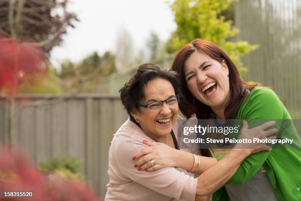 hispanic mother and daughter hugging - mama latina stock-fotos und bilder