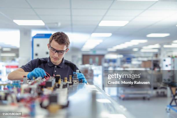 apprentice engineer in medical electronics machinery manufacturing factory - aprendiz fotografías e imágenes de stock