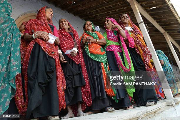 Indian female voters wait in line to cast their ballot in the state assembly elections at Sanand town, some 30 kms from Ahmedabad on December 13,...