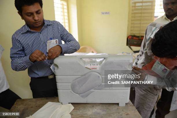 Indian officials seal an Electronic Voting Machine at a voting centre for the state assembly elections at Viramgam, 60 kms from Ahmedabad on December...