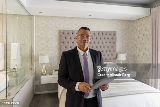 portrait of hotel manager in a luxury hotel suite - bell hop stock pictures, royalty-free photos & images