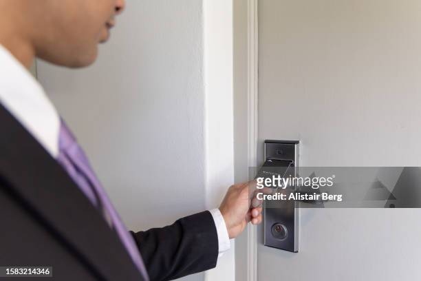 man unlocking hotel room door with keycard - keycard access stock pictures, royalty-free photos & images