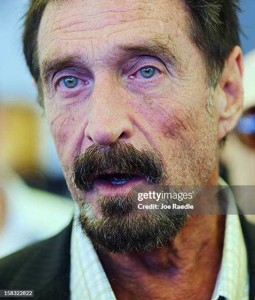 John McAfee talks to the media outside Beacon Hotel where he is staying after arriving last night from Guatemala on December 13, 2012 in Miami Beach,...