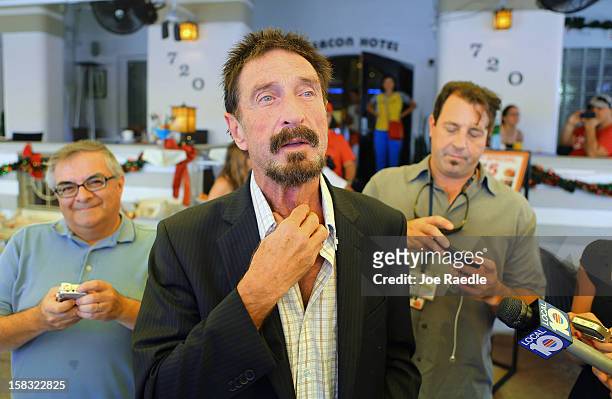 John McAfee talks to the media outside Beacon Hotel where he is staying after arriving last night from Guatemala on December 13, 2012 in Miami Beach,...