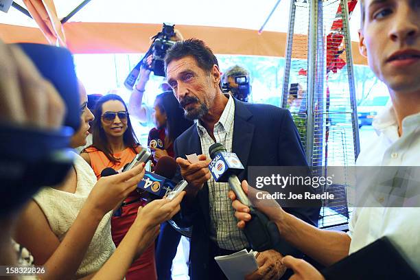 John McAfee talks to the media outside Beacon Hotel where he is staying after arriving last night from Guatemala on December 13, 2012 in Miami Beach,...