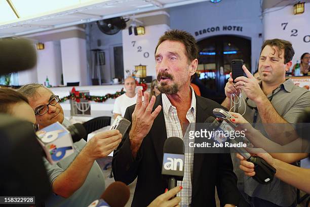 John McAfee talks to the media outside Beacon Hotel where he is staying after arriving last night from Guatemala on December 13, 2012 in Miami Beach,...