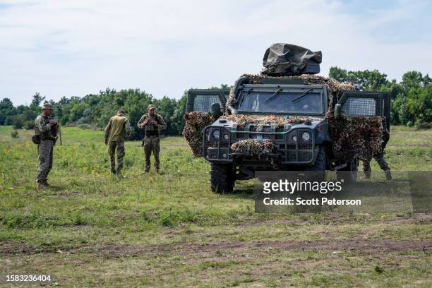Military vehicles is camouflaged as Ukrainian soldiers of the 128th Brigade of the Territorial Defense pause from their duties on the southern...