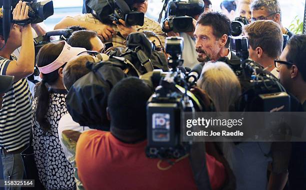 John McAfee talks to the media outside Beacon Hotel where he is staying after arriving last night from Guatemala on December 13, 2012 in Miami Beach,...