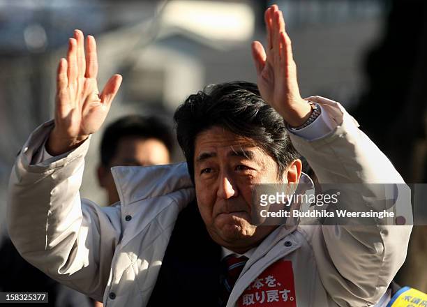Former Prime Minister and leader of Japan's main opposition Liberal Democratic Party Shinzo Abe gives a speech from the roof of a campaign car during...