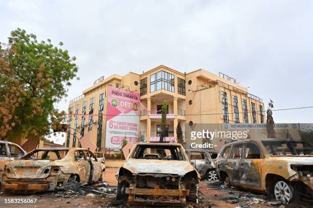 Burned cars are seen outside the headquarters of president Bazoum's Nigerien Party for Democracy and Socialism in Niamey on August 7, 2023. Niger's...