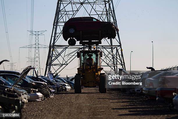 An employee positions a scrapped vehicle chassis using a front-loader in the yard of the Desguaces La Torre scrapyard in Madrid, Spain, on Thursday,...