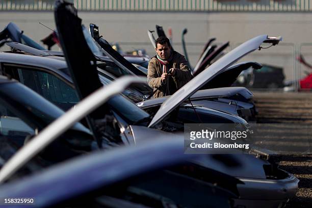Customer inspects windscreen wiper blades while checking for spare parts on a scrapped automobile in the yard of the Desguaces La Torre scrapyard in...