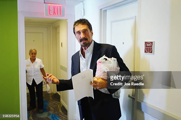 John McAfee walks to his room at the Beacon Hotel where he is staying after arriving last night from Guatemala on December 13, 2012 in Miami Beach,...