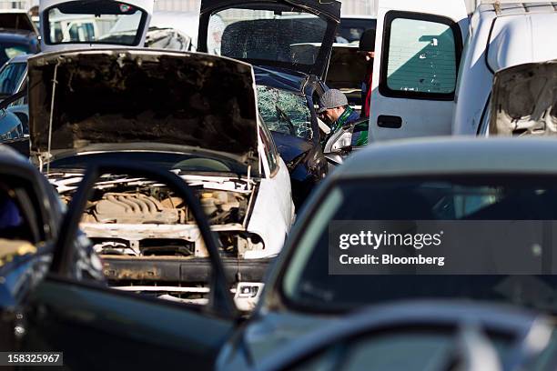 Customer searches for a spare part from a scrapped automobile in the yard of the Desguaces La Torre scrapyard in Madrid, Spain, on Thursday, Dec. 13,...