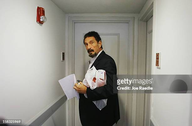 John McAfee prepares to enter his room at the Beacon Hotel where he is staying after arriving last night from Guatemala on December 13, 2012 in Miami...