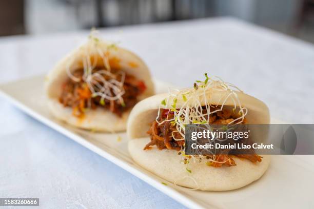 pork belly bao buns with carrots, coleslaw and cilantro with a savory sauce - pork belly stock pictures, royalty-free photos & images